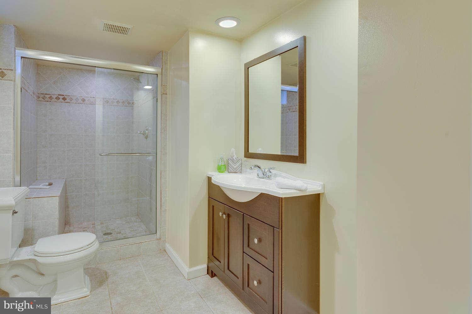 1524 Laurel Hill Road Vienna, VA 22182 - Photo 22 of 29 a bathroom with a granite countertop sink toilet and shower