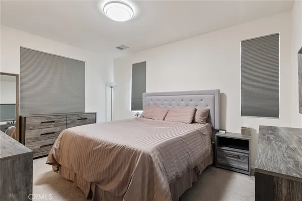 a large bedroom with a bed and a flat screen tv