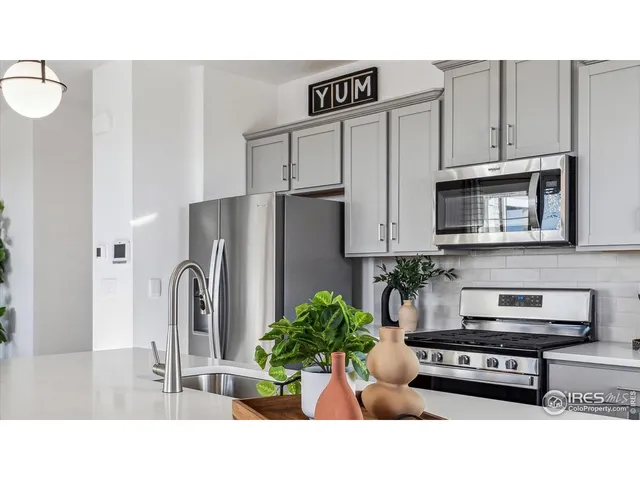 a kitchen with stainless steel appliances kitchen island granite countertop a refrigerator a stove and a sink