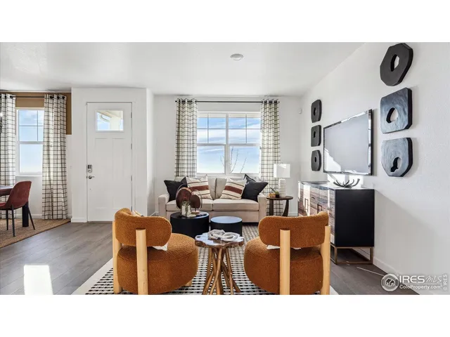 a living room with furniture a window and wooden floor