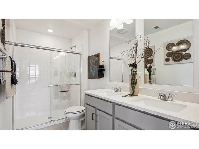 a bathroom with a sink a toilet a mirror and shower