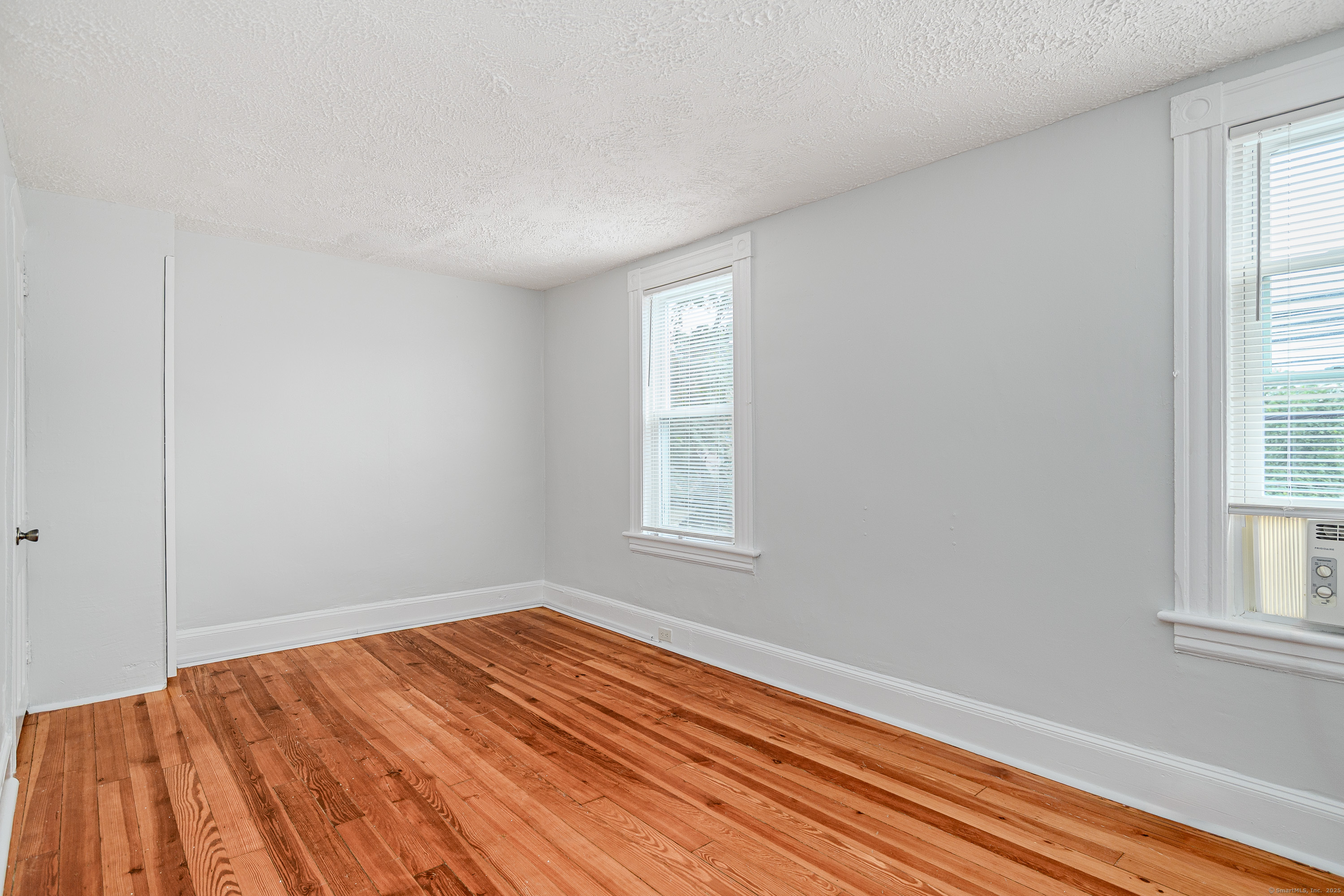316 Reef Road Fairfield, CT 06824 - Photo 19 of 33 an empty room with wooden floor and windows