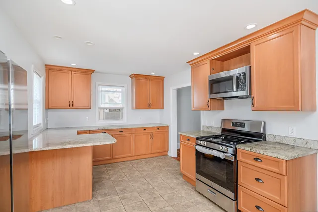 a kitchen with stainless steel appliances granite countertop a sink stove and microwave
