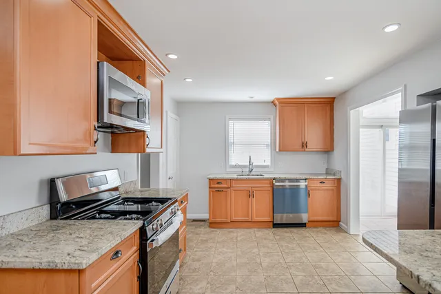 a kitchen with stainless steel appliances granite countertop a stove top oven a sink and dishwasher