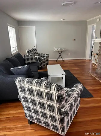a living room with a bed and wooden floor