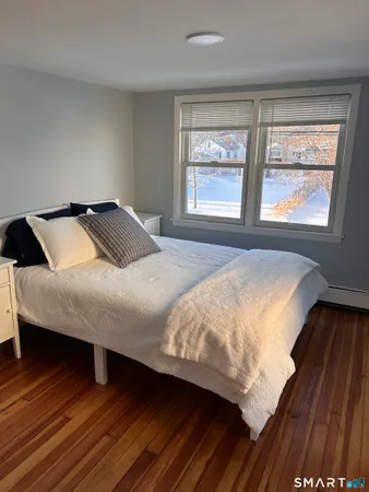 a bedroom with a bed and wooden floor