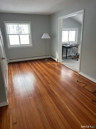 an empty room with wooden floor and a window