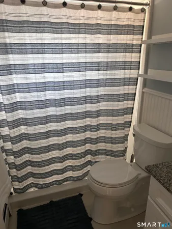 a bathroom with a toilet and a shower curtain
