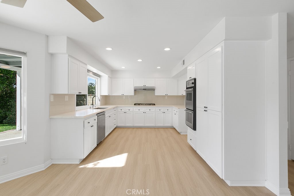 29950 Rolling Ridge Drive Agoura Hills, CA 91301 - Photo 7 of 26 a large white kitchen with a sink and dishwasher a refrigerator with wooden floor