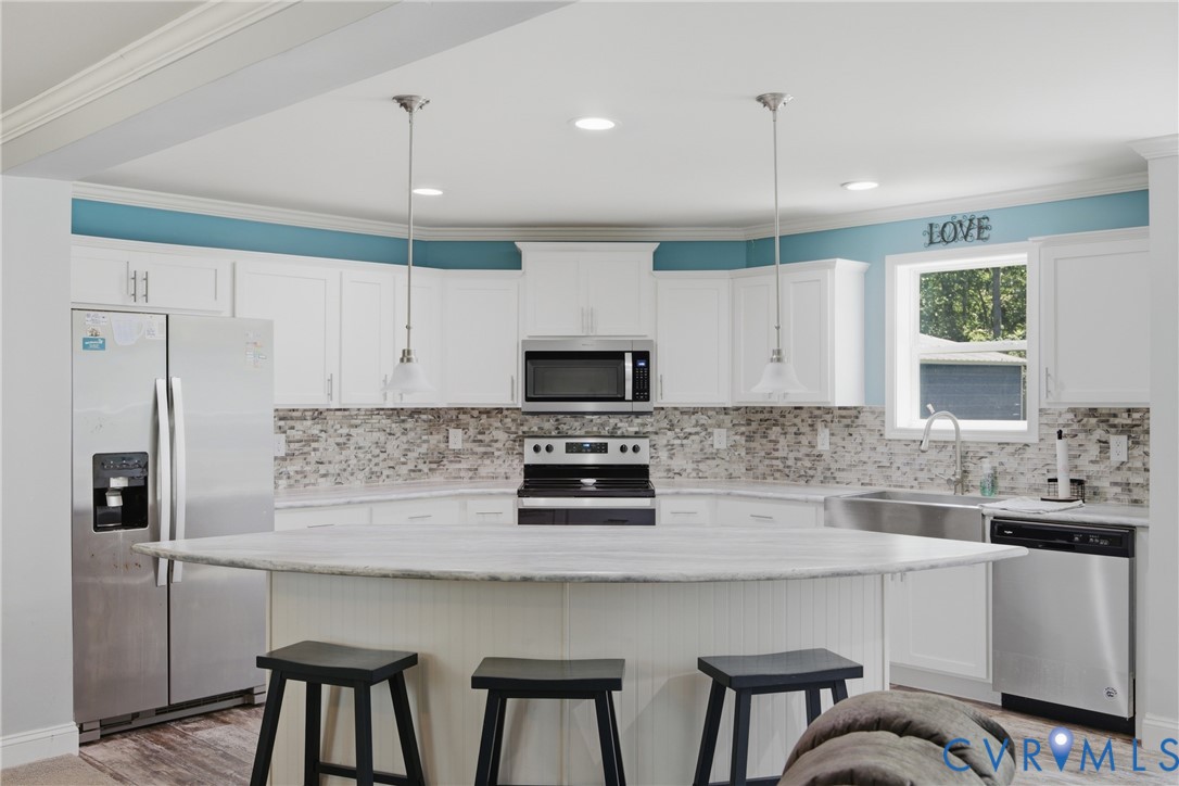 93 Faraway Road Saluda, VA 23149 - Photo 12 of 58 a kitchen with stainless steel appliances a table chairs refrigerator and microwave