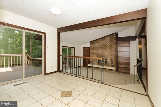 a view of a livingroom with wooden floor and a fireplace