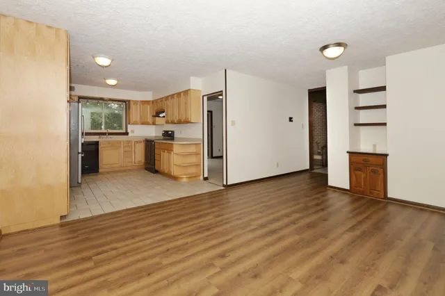 a view of a livingroom with wooden floor and a ceiling fan