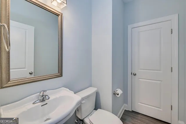 a bathroom with a toilet a sink and mirror