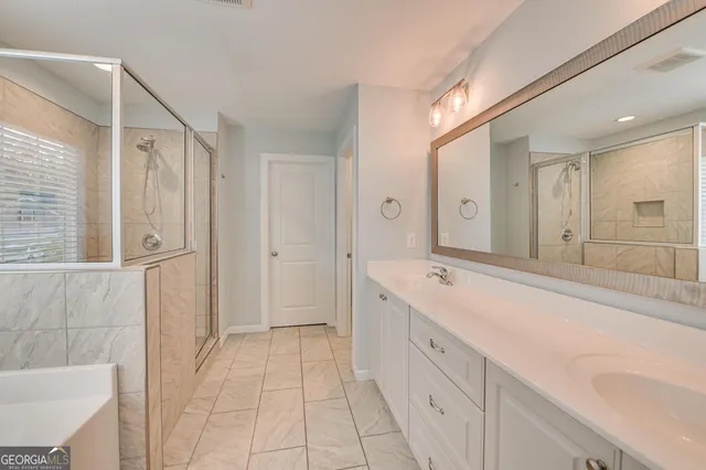 a spacious bathroom with a shower sink and mirror