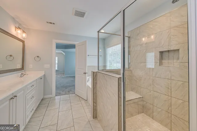 a bathroom with a double vanity sink a toilet and shower