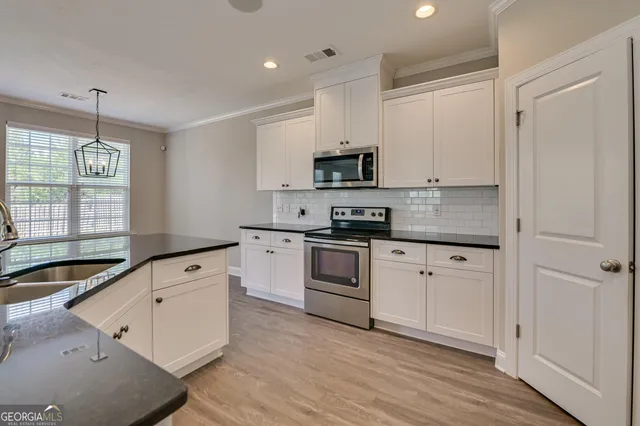 a kitchen with granite countertop white cabinets and white appliances