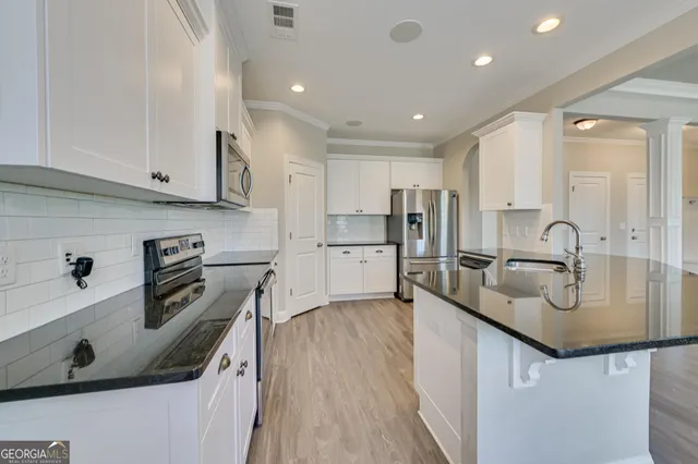 a kitchen with stainless steel appliances granite countertop a sink stove and refrigerator