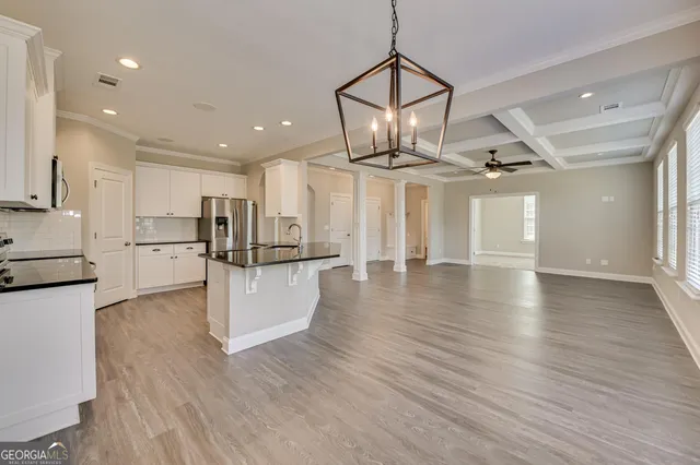 a view of a kitchen with a sink and wooden floor