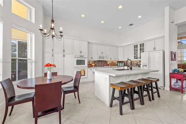 a kitchen with stainless steel appliances a table and chairs in it