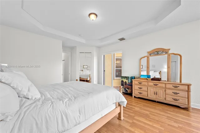 a large bedroom with a large bed and wooden floor