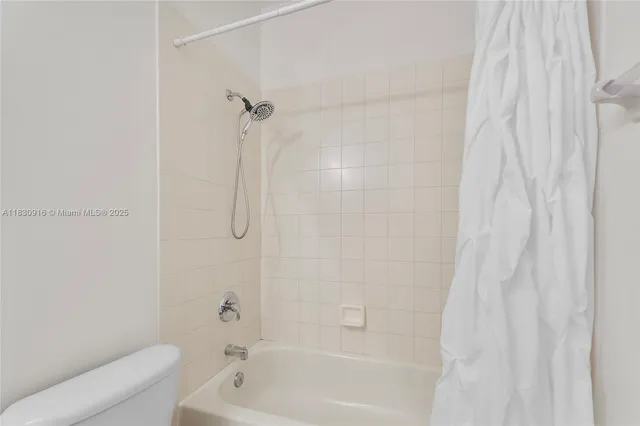 a bathroom with a shower curtain and a bath tub