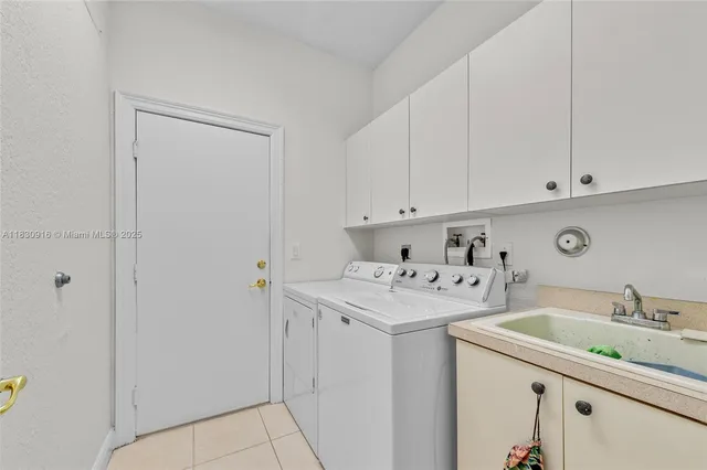 a utility room with cabinets washer and dryer