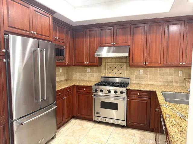 a kitchen with stainless steel appliances granite countertop a refrigerator sink and cabinets