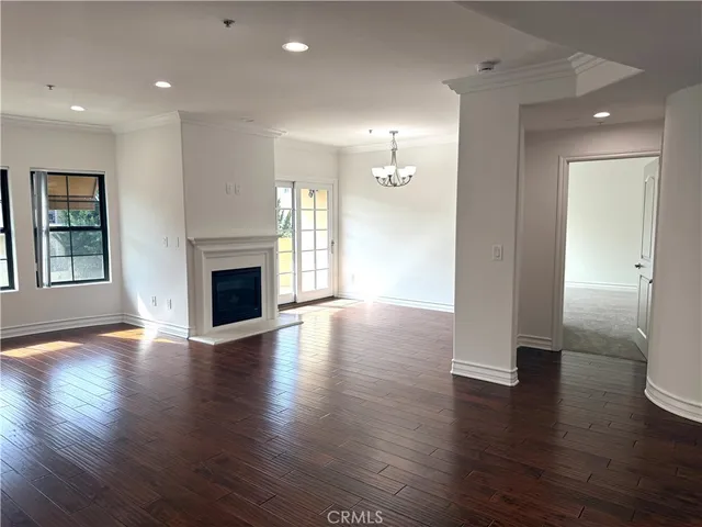 an empty room with wooden floor and fireplace