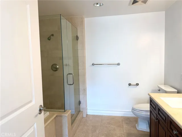 a bathroom with a granite countertop toilet and a shower