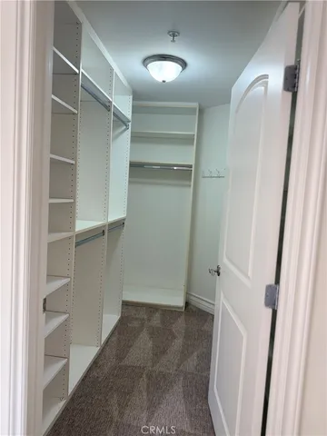 a view of walk in closet with empty racks