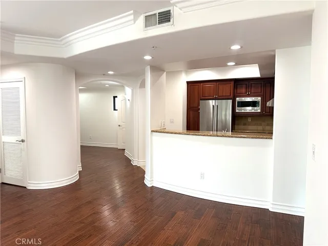 a view of a hallway with wooden floor and a bathroom