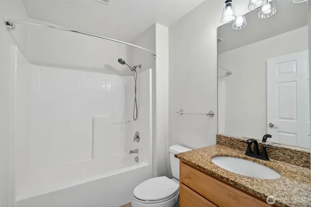 a bathroom with a granite countertop sink toilet mirror and shower