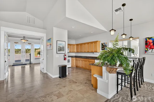 a view of a dining room and livingroom with furniture wooden floor a chandelier