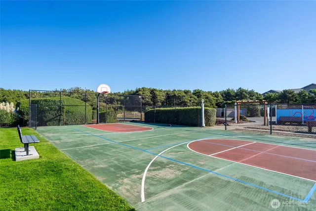 a view of a tennis ground with large trees