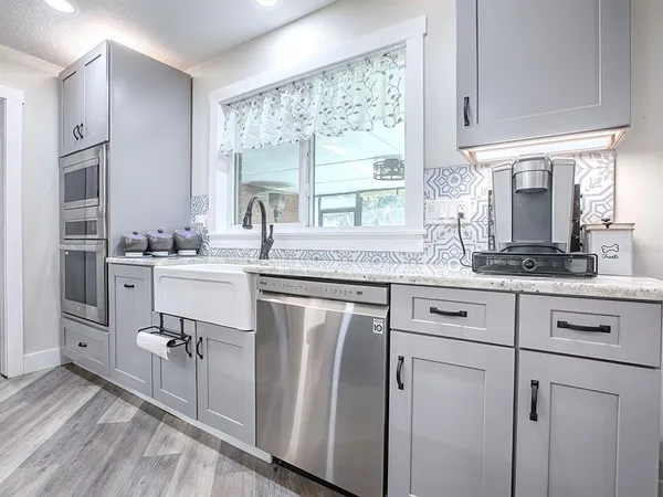 a kitchen with cabinets appliances a sink and a window
