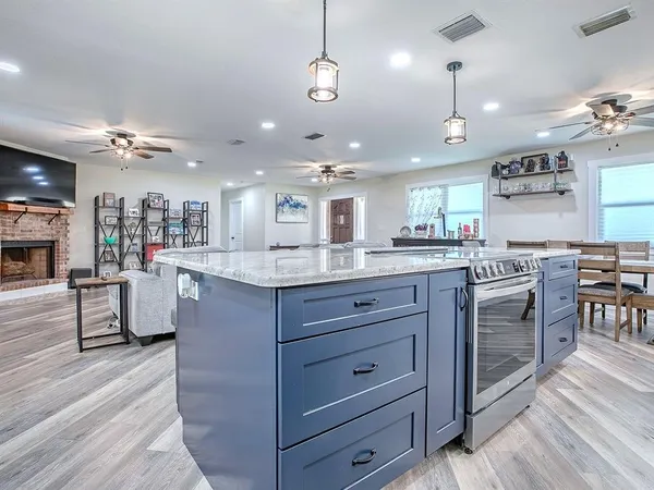 a large kitchen with a center island and stainless steel appliances