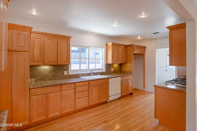a kitchen with stainless steel appliances granite countertop a stove a sink and a refrigerator
