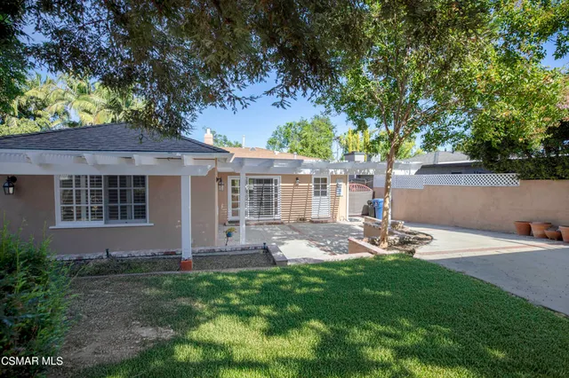 a backyard of a house with garden and outdoor seating