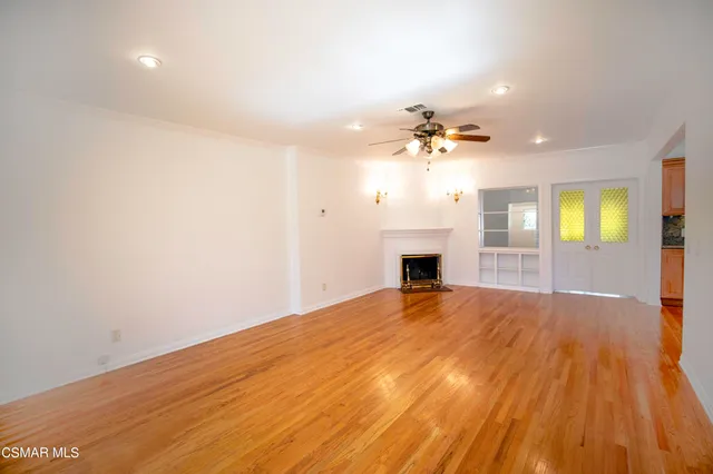 a view of an empty room with a fireplace and a window