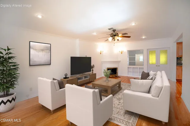 a living room with furniture a chandelier and a flat screen tv