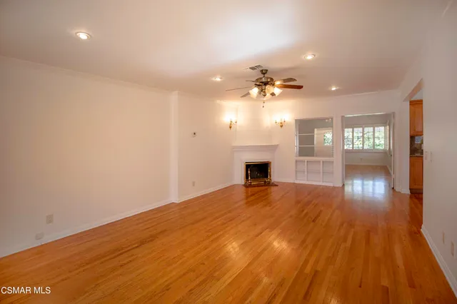a view of empty room with wooden floor and fireplace