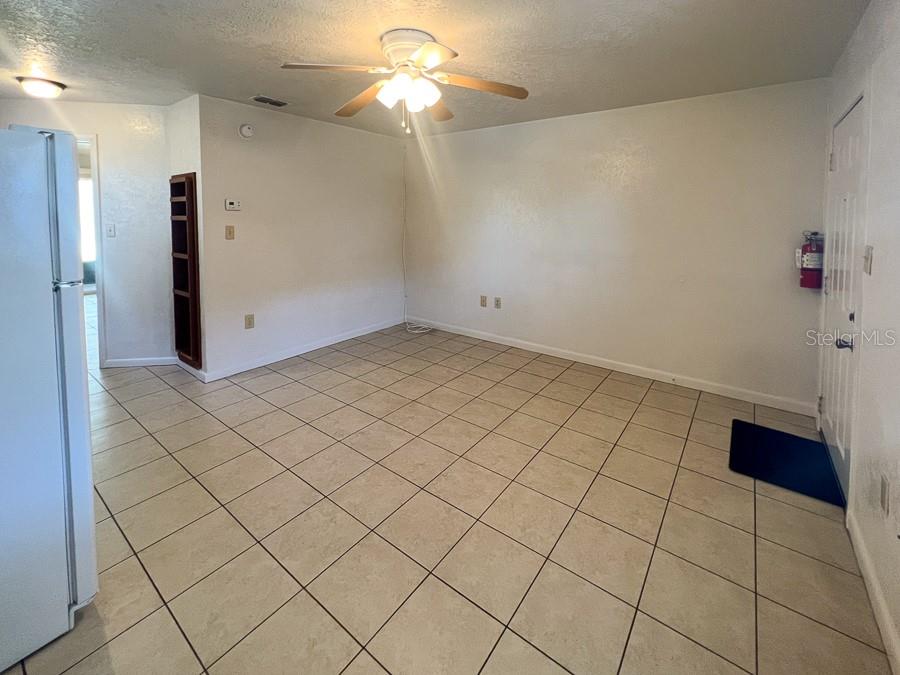 1406 Southwest 18th Place, Unit 11 Gainesville, FL 32608 - Photo 4 of 16 an empty room with windows and fan
