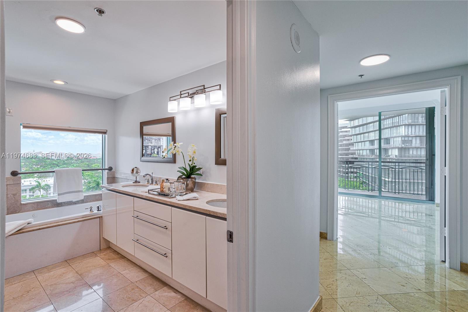3400 Southwest 27th Avenue, Unit 906 Miami, FL 33133 - Photo 14 of 35 a large white bathroom with a double vanity sink and a large mirror
