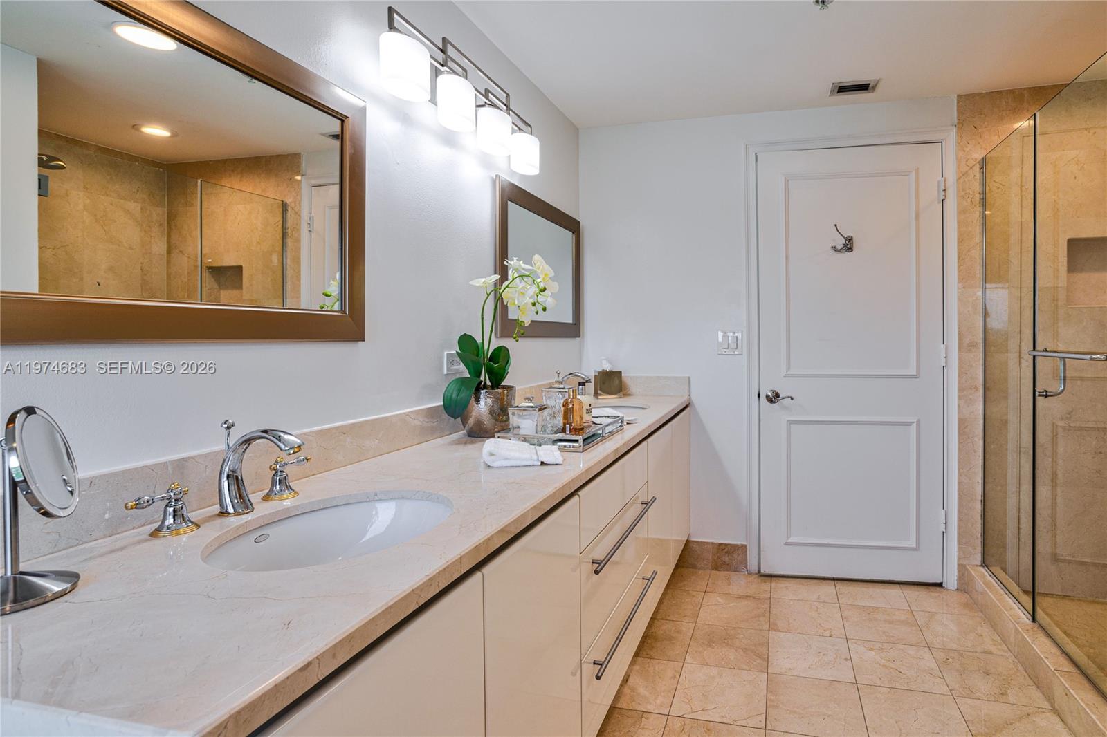3400 Southwest 27th Avenue, Unit 906 Miami, FL 33133 - Photo 16 of 35 a bathroom with a sink and a mirror
