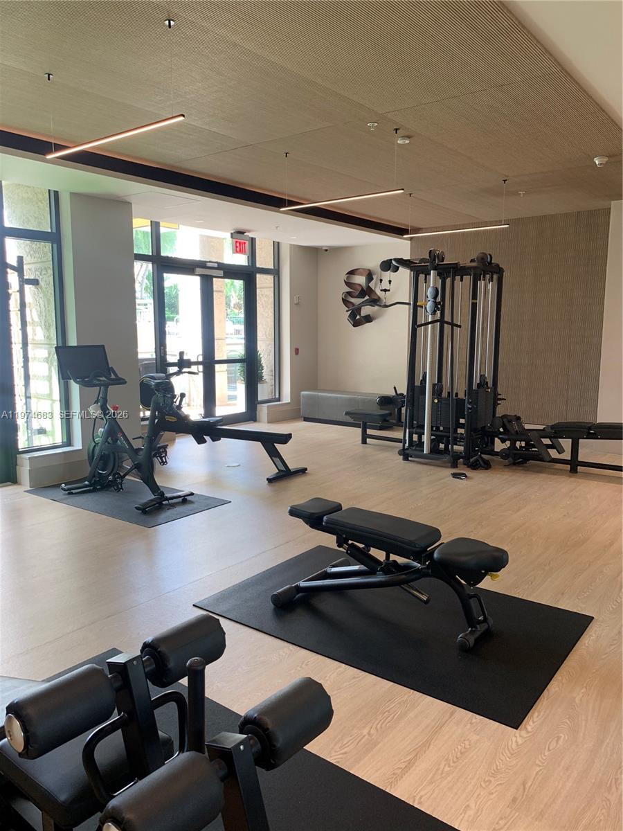 3400 Southwest 27th Avenue, Unit 906 Miami, FL 33133 - Photo 34 of 35 a room with gym equipment and a large window