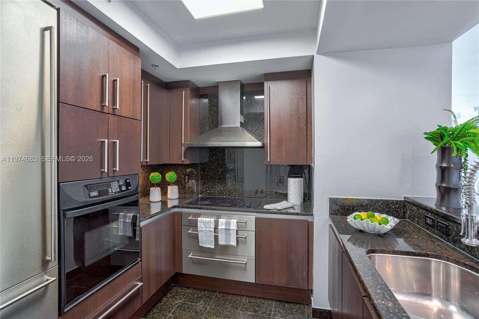 3400 Southwest 27th Avenue, Unit 906 Miami, FL 33133 - Photo 8 of 35 a kitchen with a sink stove and cabinets
