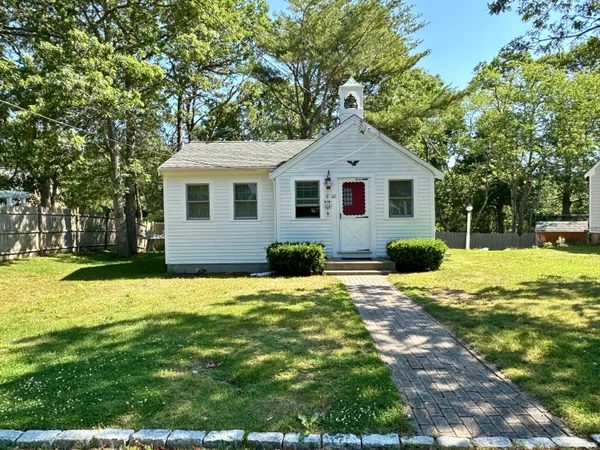 a front view of house with yard and trees around