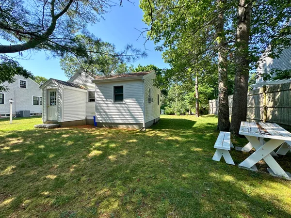 a view of a house with backyard and tree
