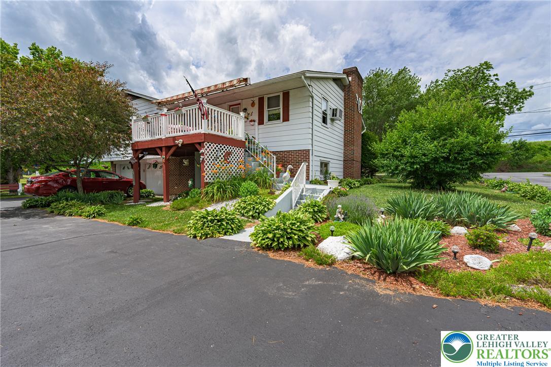 678 Interchange Road Kresgeville, PA 18333 - Photo 12 of 45 Mature trees and vibrant landscaping frame this charming residence, boasting a welcoming upper-level deck.