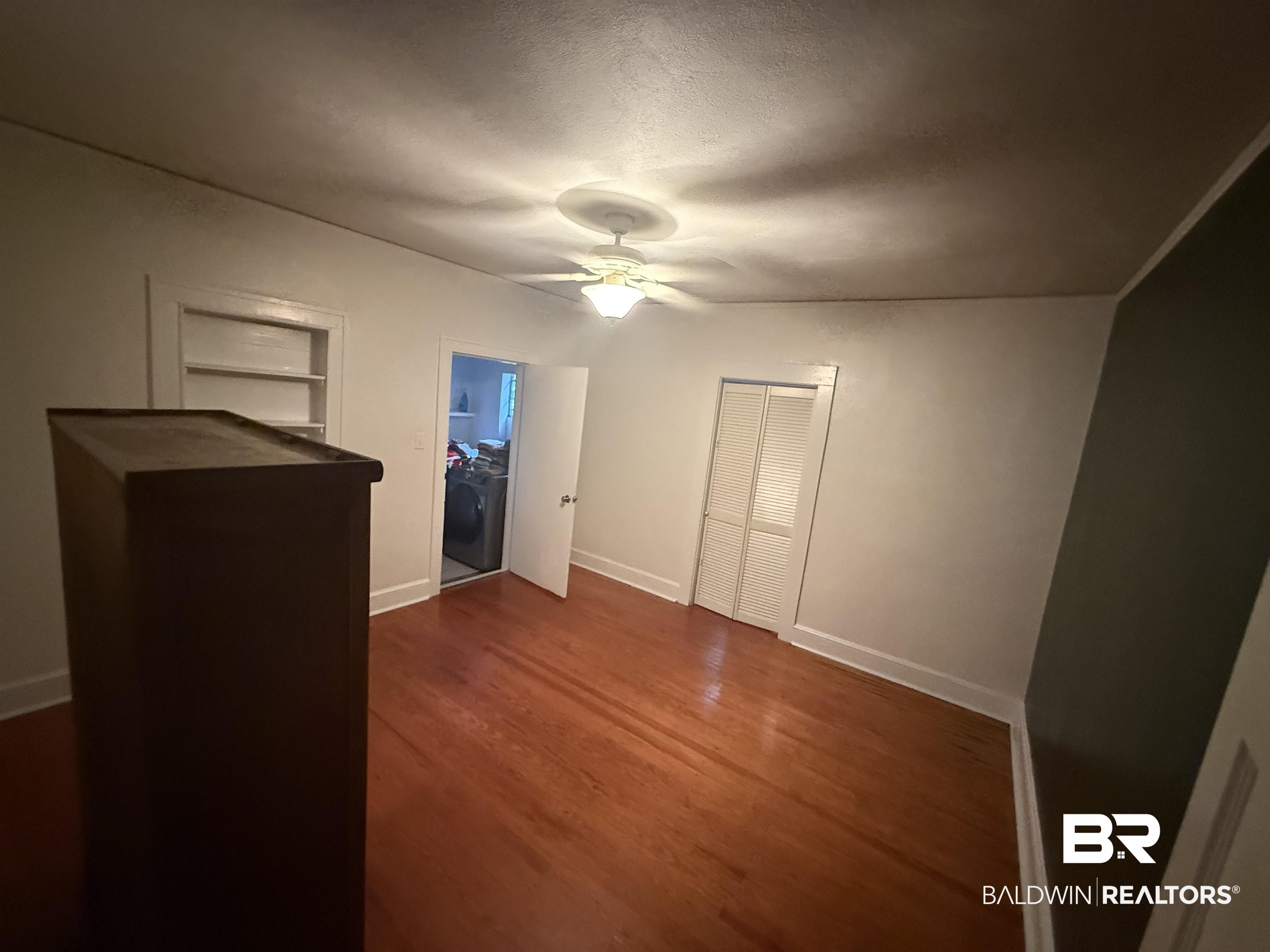 266 Westwood Street Mobile, AL 36606 - Photo 33 of 34 Unfurnished bedroom featuring dark wood-style floors, ceiling fan, and a closet